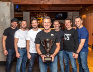 Group of men gathered in a bar celebrating a fantasy football league championship.