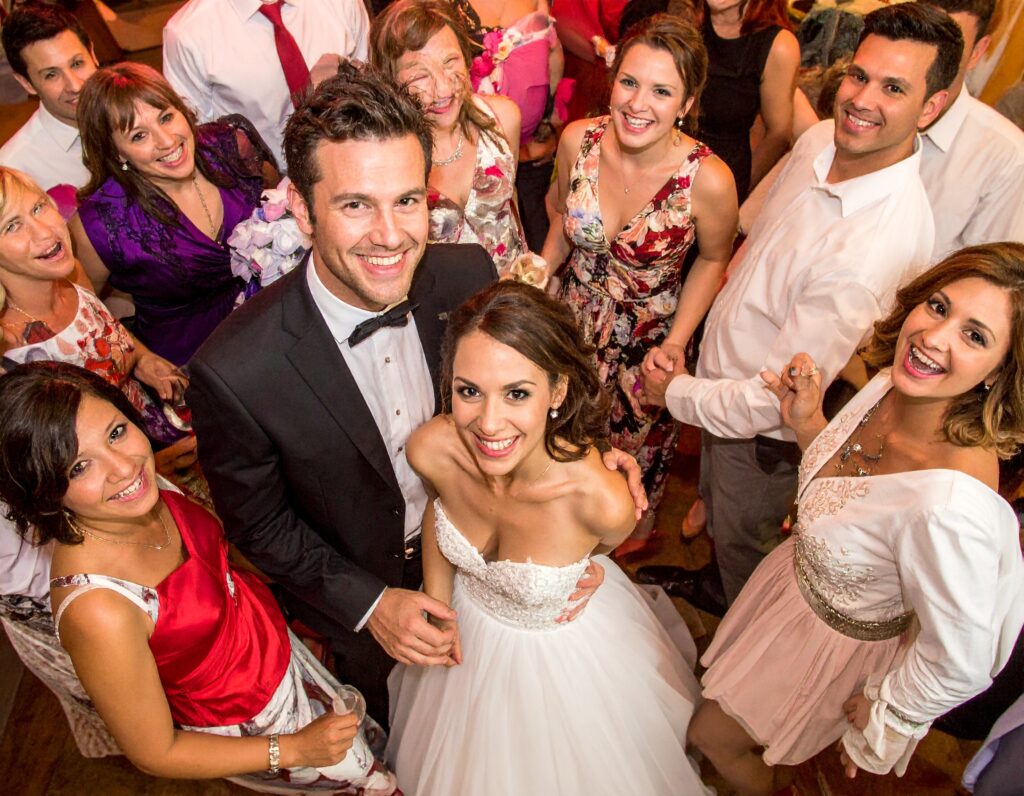Group of friends at a wedding dancing with the bride and groom.