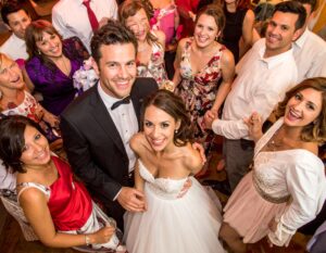 Group of friends at a wedding dancing with the bride and groom. 