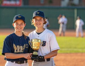 A high school aged boy and girl posing with their season MVP trophy. 