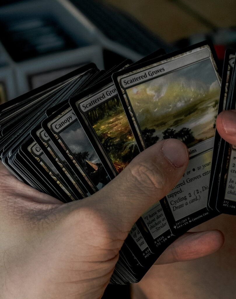 stack of Magic: The Gathering Cards being held in someone's hand.