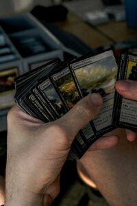 stack of Magic: The Gathering Cards being held in someone's hand. 